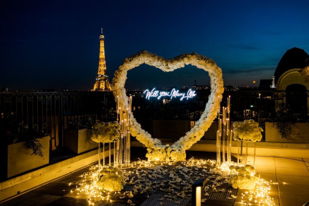 Arche en coeur avec néon will you marry me sur un rooftop à Paris avec vue sur Tour Eiffel